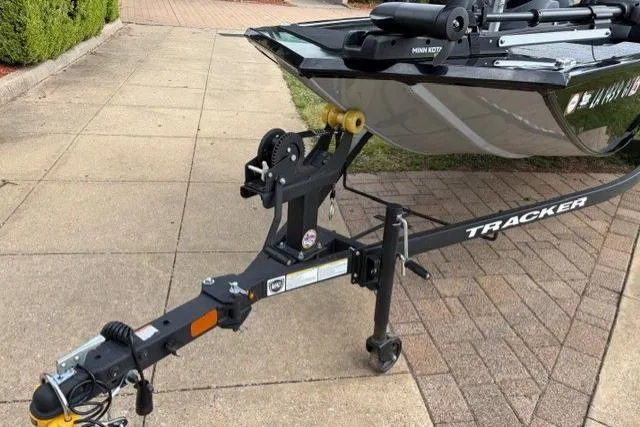 Slide: The Image of 2025 Tracker Pro 170 boat trailer parked on a paved driveway. - 12