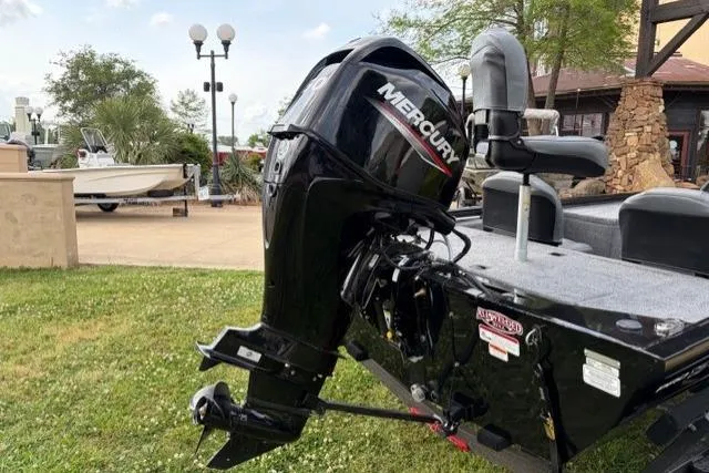 Slide: The Image of 2025 Tracker Pro 170 boat with Mercury outboard motor, parked on grass. - 5