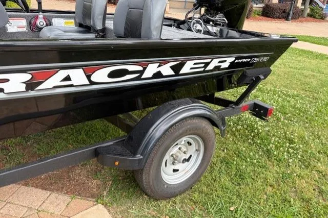 Slide: The Image of 2025 Tracker Pro 170 boat on trailer, black exterior, parked on grass. - 8