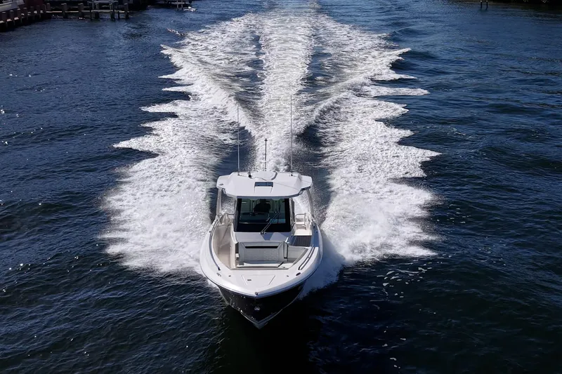 Slide: The Image of 2023 Tiara Sport 34 LS cruising on open water, leaving a dynamic wake trail. - 11