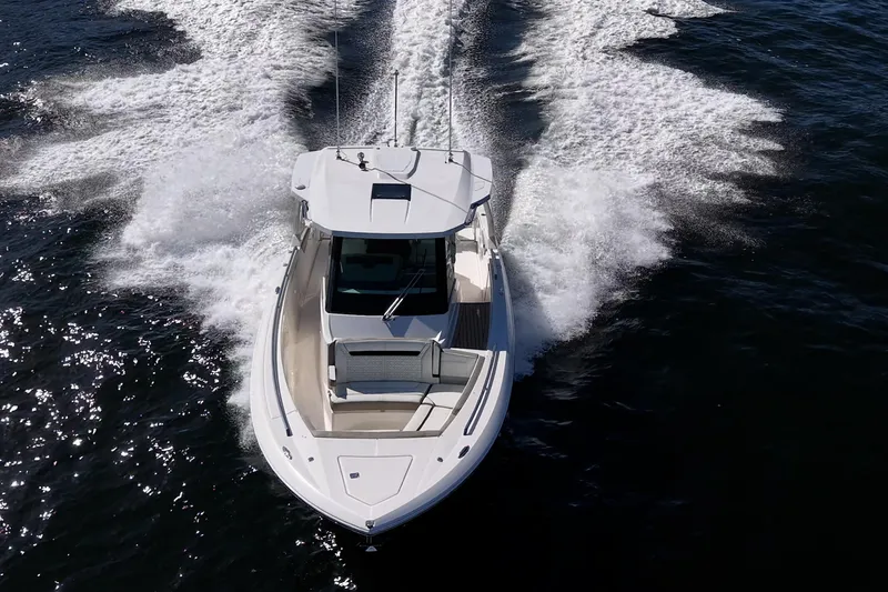 Slide: The Image of 2023 Tiara Sport 34 LS boat cruising on open water, creating dynamic wake patterns. - 12