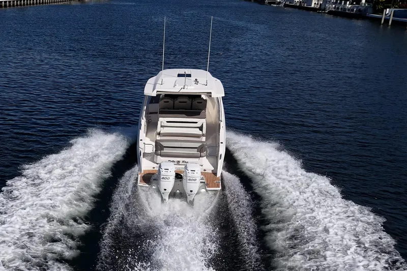 Slide: The Image of 2023 Tiara Sport 34 LS boat cruising on open water, rear view. - 2