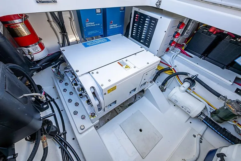 Slide: The Image of Engine compartment of 2023 Tiara Sport 34 LS, featuring battery chargers and electrical systems. - 26