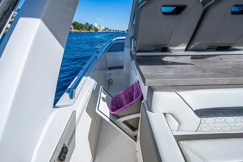 Slide: The Image of 2023 Tiara Sport 34 LS boat interior with seating and storage, cruising on a sunny day. - 40