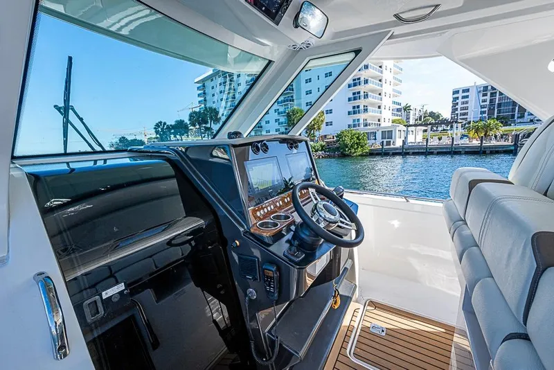 Slide: The Image of 2023 Tiara Sport 34 LS boat interior with modern dashboard and waterfront view. - 41