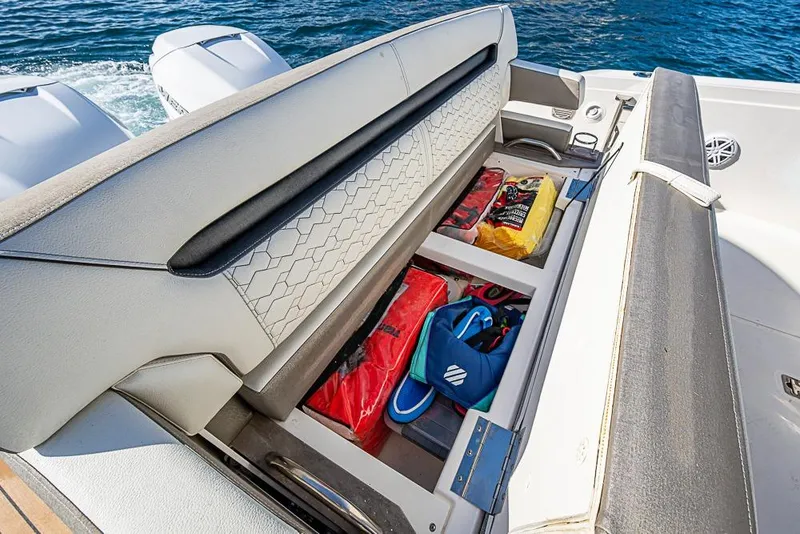 Slide: The Image of 2023 Tiara Sport 34 LS boat with open storage compartment, revealing gear and equipment. - 46
