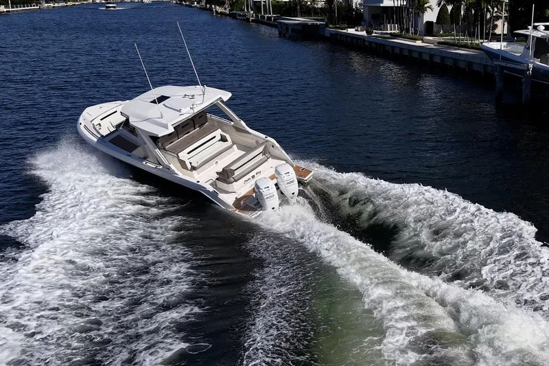 Slide: The Image of 2023 Tiara Sport 34 LS cruising on a scenic waterway, showcasing sleek design and powerful engines. - 6