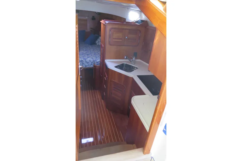 Slide: The Image of Interior of 2007 Hinckley Talaria 40 yacht with wooden cabinetry and compact kitchen area. - 23