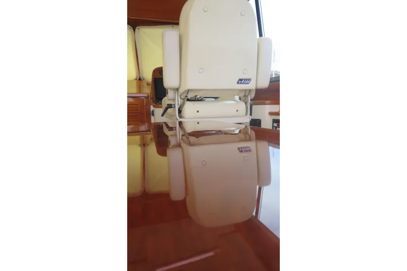 Slide: The Image of Captain's chair on 2007 Hinckley Talaria 40 yacht, reflected on polished wooden surface. - 29