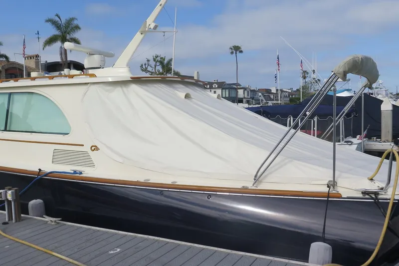 Slide: The Image of 2007 Hinckley Talaria 40 yacht docked, covered with a protective tarp, in a marina setting. - 8