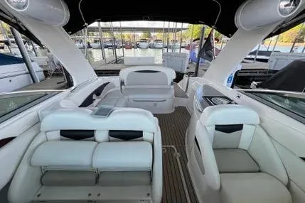 Slide: The Image of 2007 Chaparral 276 SSX boat interior with white seating and wood flooring at a marina. - 2