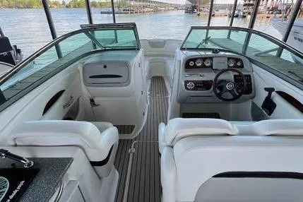 Slide: The Image of 2007 Chaparral 276 SSX boat interior with dual seating and dashboard, docked by the water. - 6