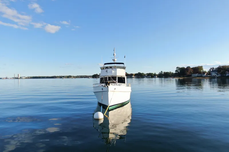 Slide: The Image of 1989 Grand Banks 46 Classic yacht moored on calm water under clear blue sky. - 11