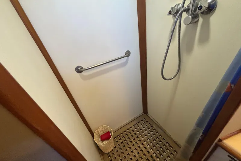 Slide: The Image of Shower area in 1989 Grand Banks 46 Classic yacht with wooden floor and metal fixtures. - 110