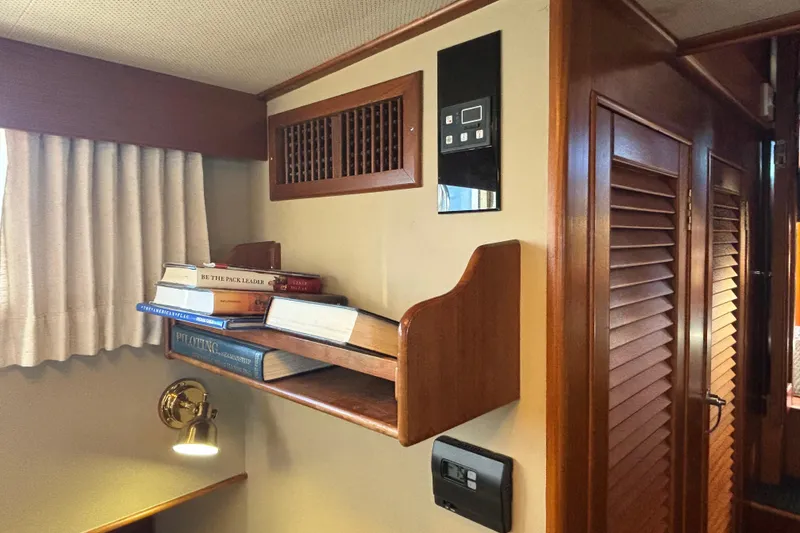 Slide: The Image of 1989 Grand Banks 46 Classic interior with bookshelf, wooden paneling, and wall-mounted controls. - 111