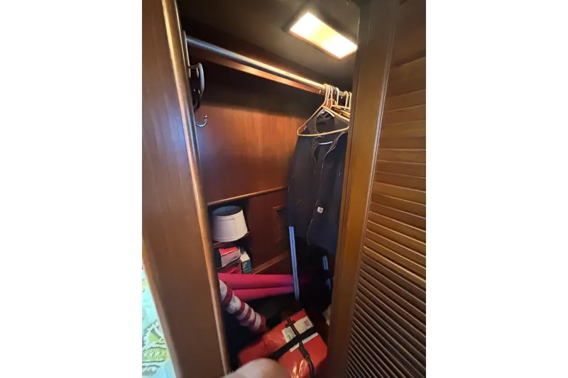 Slide: The Image of Closet interior on 1989 Grand Banks 46 Classic yacht with clothes and storage items. - 115