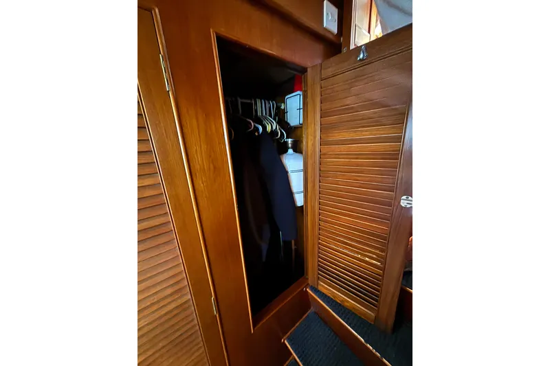 Slide: The Image of Wooden closet interior on 1989 Grand Banks 46 Classic yacht, with hanging clothes and storage. - 116