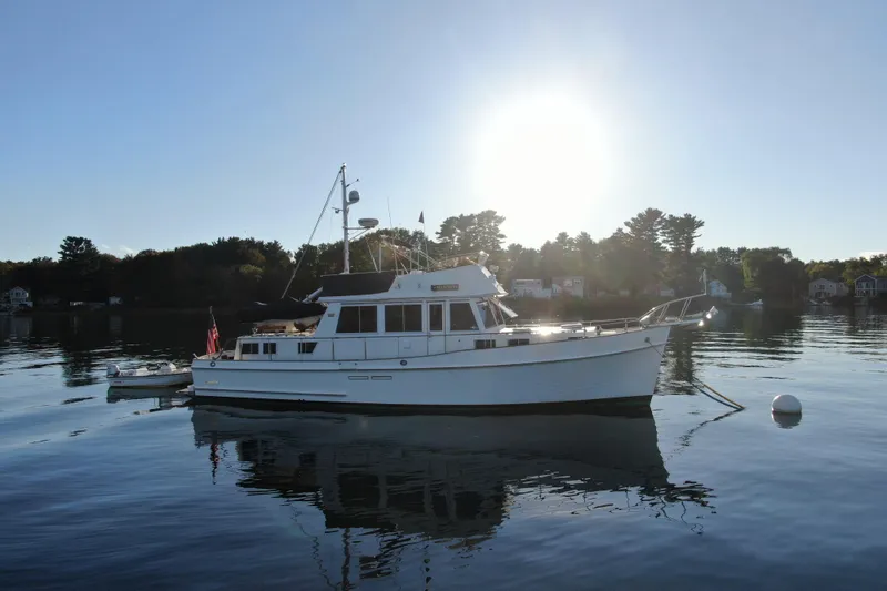 Slide: The Image of 1989 Grand Banks 46 Classic yacht on calm water at sunset. - 12