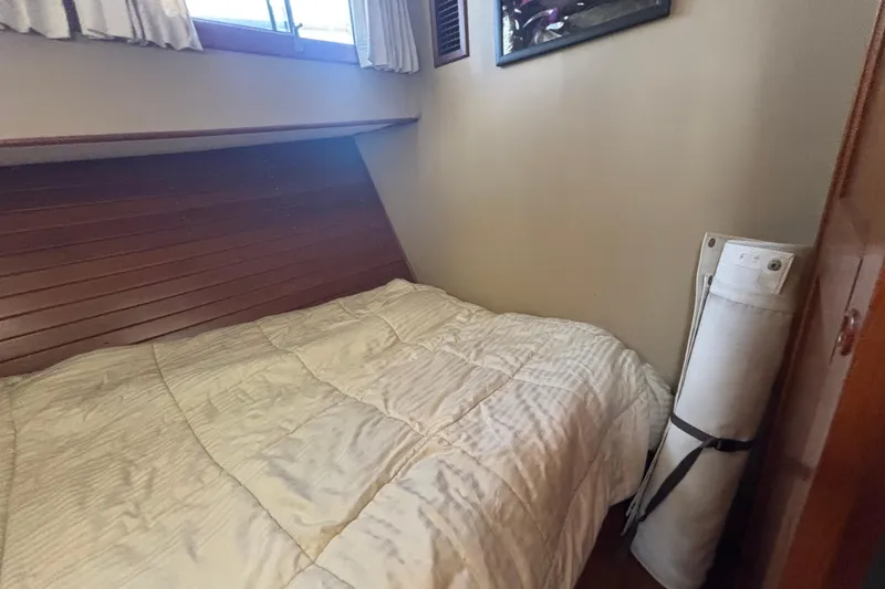 Slide: The Image of Cozy cabin interior of 1989 Grand Banks 46 Classic with bed and rolled-up canvas. - 120