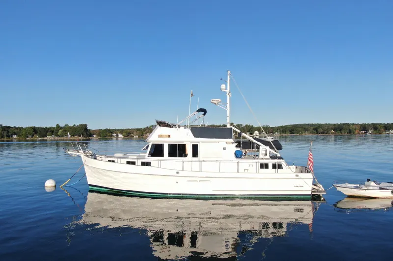 Slide: The Image of 1989 Grand Banks 46 Classic yacht on calm water, clear sky background. - 13