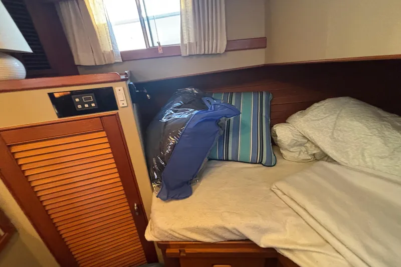 Slide: The Image of Cozy cabin interior of 1989 Grand Banks 46 Classic yacht with bed and striped pillows. - 131