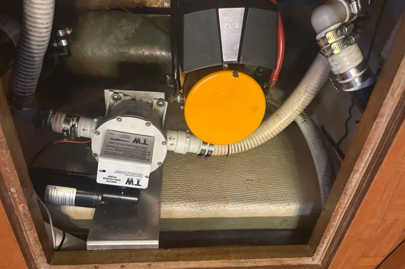 Slide: The Image of Engine compartment of a 1989 Grand Banks 46 Classic boat with visible pump and hoses. - 157