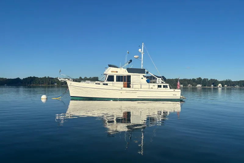 Slide: The Image of 1989 Grand Banks 46 Classic yacht on calm water under clear blue sky. - 16