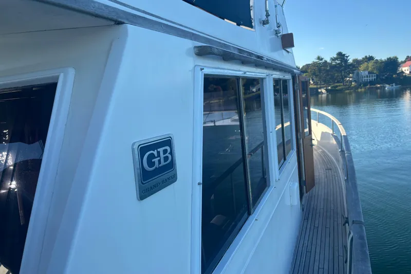 Slide: The Image of 1989 Grand Banks 46 Classic yacht on serene water, showcasing elegant design and craftsmanship. - 27