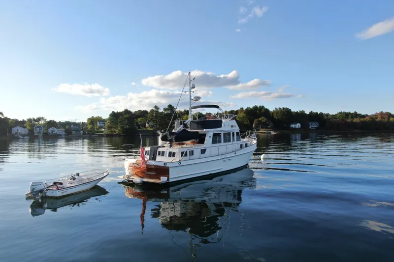 Slide: The Image of 1989 Grand Banks 46 Classic yacht on calm water with scenic background. - 3