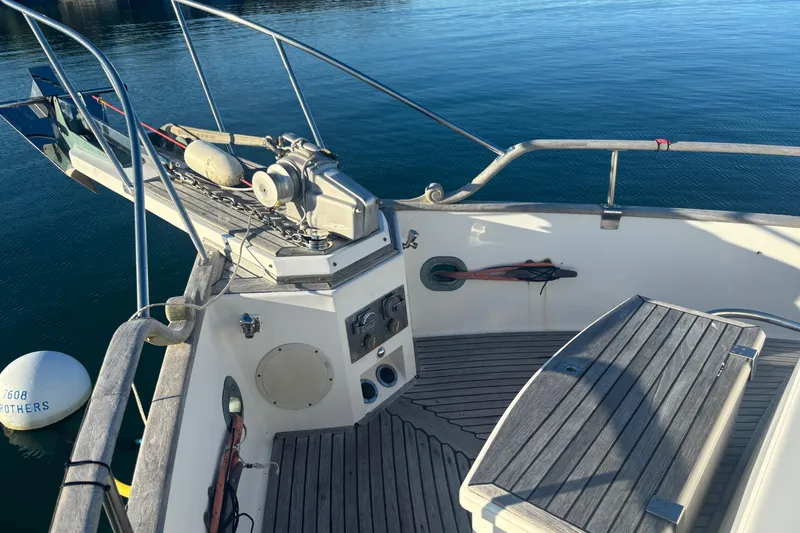 Slide: The Image of 1989 Grand Banks 46 Classic yacht deck with anchor and wooden seating. - 31