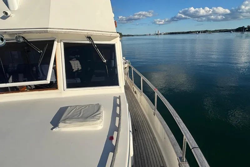 Slide: The Image of 1989 Grand Banks 46 Classic yacht on calm water under a clear blue sky. - 35