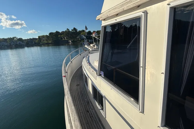 Slide: The Image of 1989 Grand Banks 46 Classic yacht on calm water, showcasing elegant design and scenic surroundings. - 39