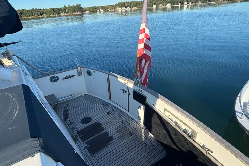 Slide: The Image of 1989 Grand Banks 46 Classic yacht deck with American flag on calm water. - 43