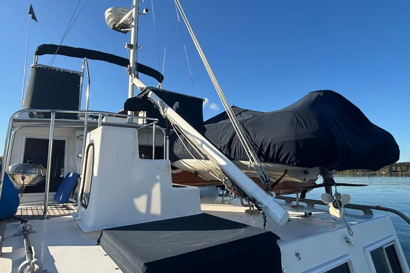 Slide: The Image of 1989 Grand Banks 46 Classic yacht deck with covered equipment, clear blue sky. - 44