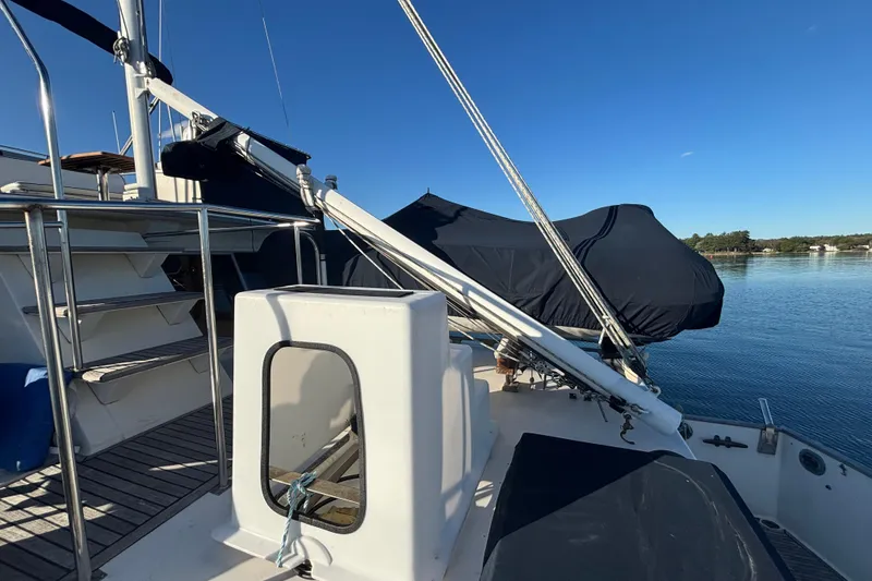 Slide: The Image of 1989 Grand Banks 46 Classic yacht deck with covered equipment, calm water, and clear sky. - 45