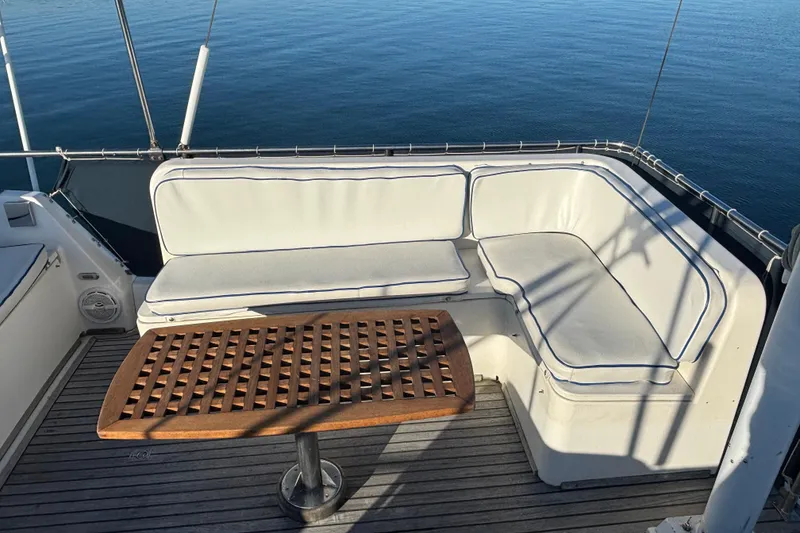 Slide: The Image of Grand Banks 46 Classic 1989 yacht with cushioned seating and wooden table on deck. - 48