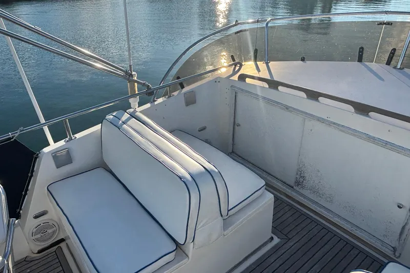 Slide: The Image of 1989 Grand Banks 46 Classic yacht deck with cushioned seating and water view. - 49