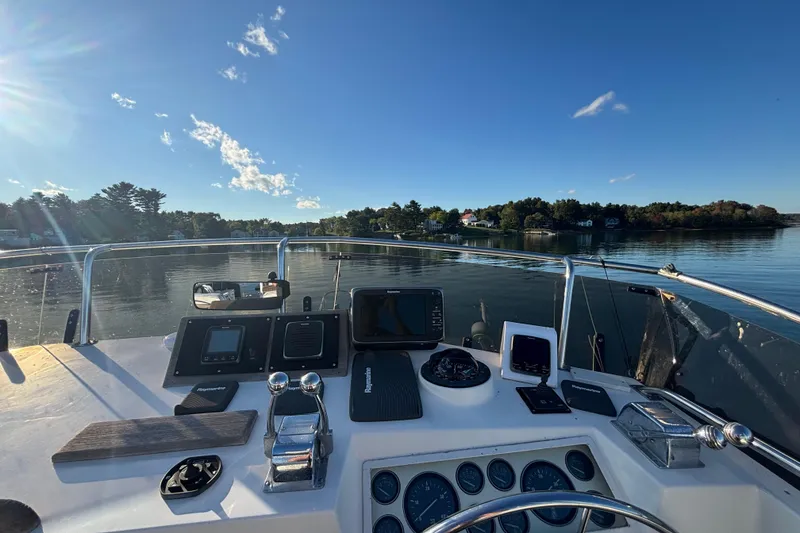 Slide: The Image of Helm of 1989 Grand Banks 46 Classic yacht with navigational instruments, overlooking calm waters. - 52