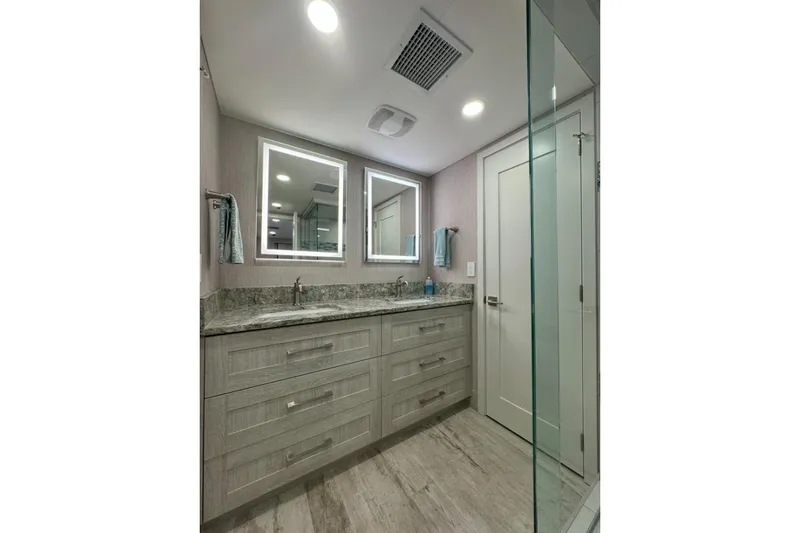Slide: The Image of Modern bathroom with dual mirrors, granite countertop, and glass shower in Adonia Layin' Low 2022. - 11