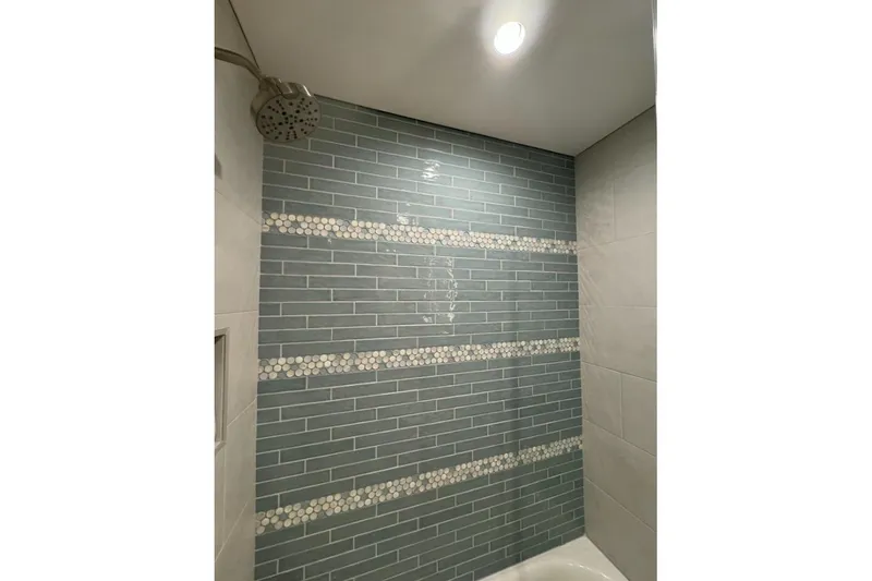 Slide: The Image of Modern shower with blue subway tiles and circular mosaic accents, Adonia Layin' Low 2022. - 17