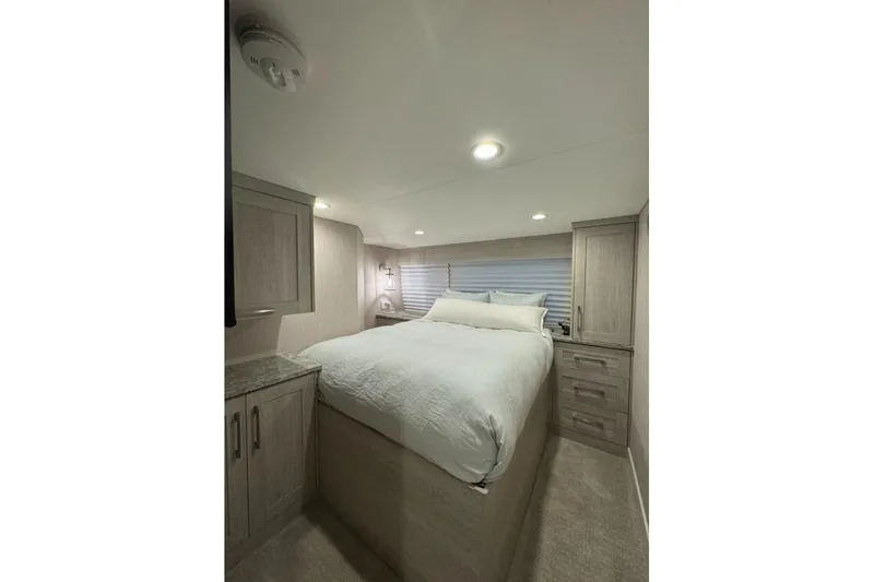Slide: The Image of 2022 Adonia Layin' Low RV bedroom with cozy bed and modern cabinetry. - 18