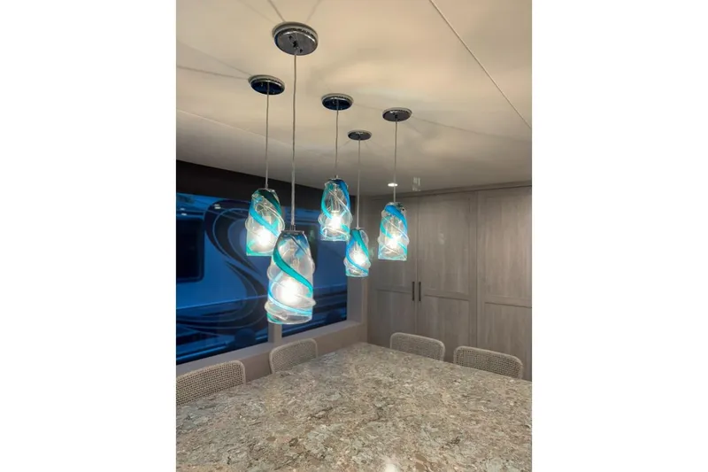 Slide: The Image of Modern dining area with elegant blue pendant lights in 2022 Adonia Layin' Low model. - 24