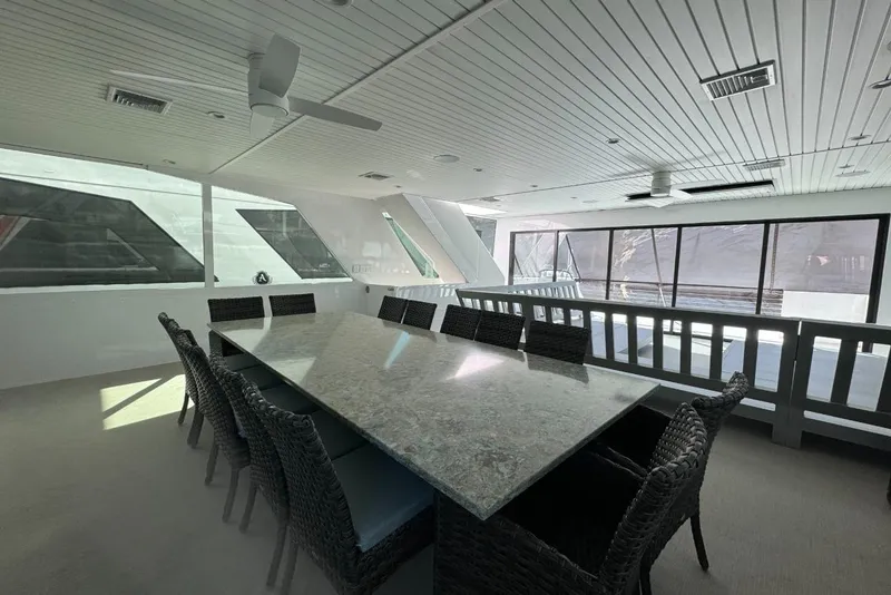 Slide: The Image of Luxurious dining area on 2022 Adonia Layin' Low yacht with elegant table and wicker chairs. - 29