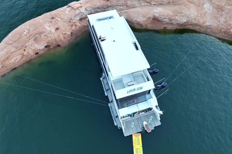 Slide: The Image of Aerial view of 2022 Adonia Layin' Low houseboat moored by rocky shoreline. - 3