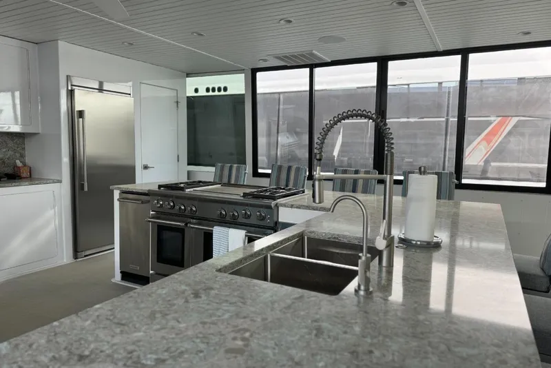 Slide: The Image of Modern kitchen interior on Adonia Layin' Low 2022, featuring stainless steel appliances and sleek countertops. - 30