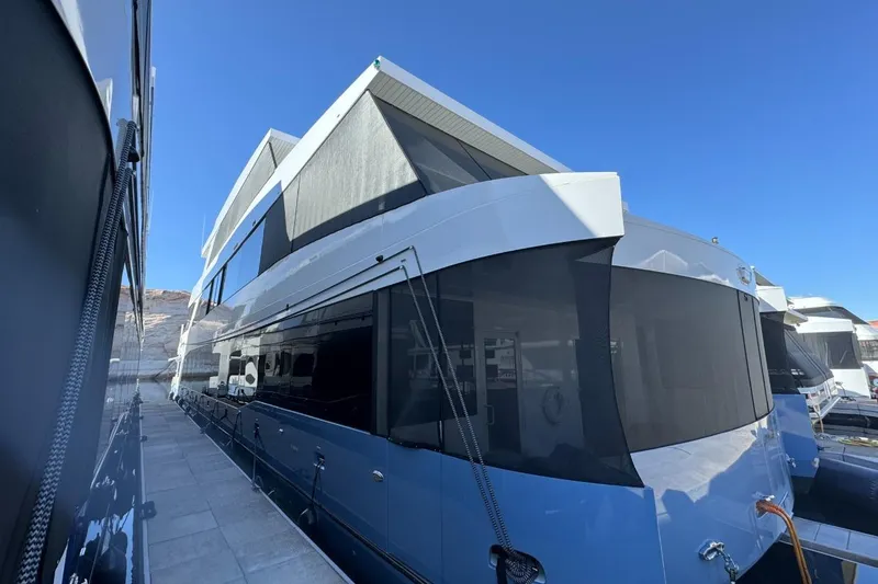 Slide: The Image of Luxury 2022 Adonia Layin' Low houseboat docked under clear blue sky. - 5