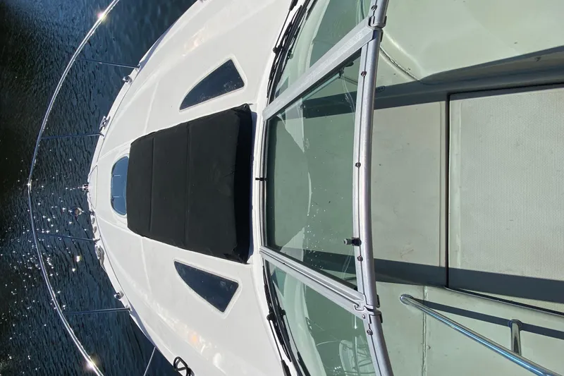 Slide: The Image of 2012 Sea Ray 330 Sundancer boat deck with glass windshield on water. - 12