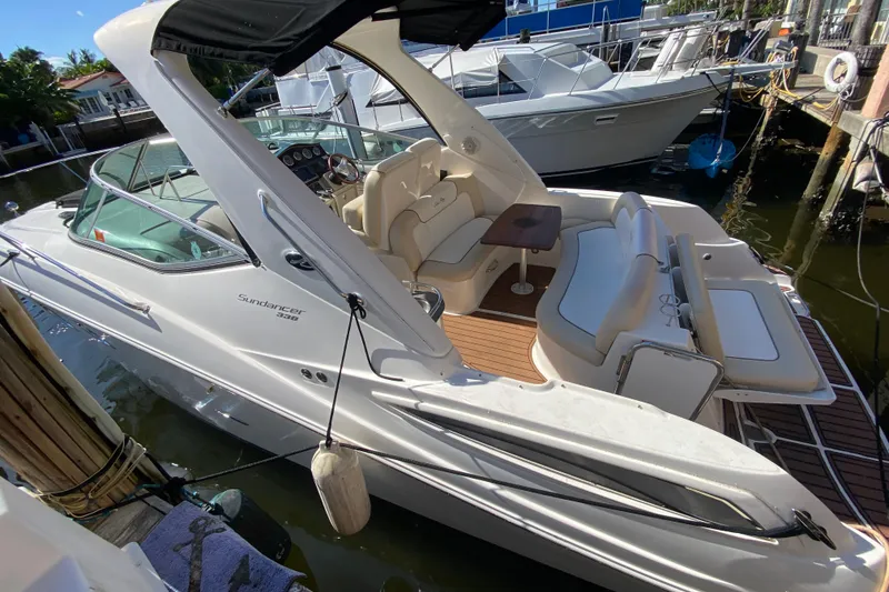 Slide: The Image of 2012 Sea Ray 330 Sundancer boat docked, featuring spacious seating and sleek design. - 14
