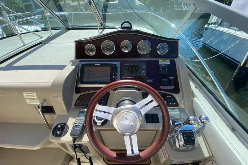 Slide: The Image of Cockpit of 2012 Sea Ray 330 Sundancer with steering wheel and navigation controls. - 25