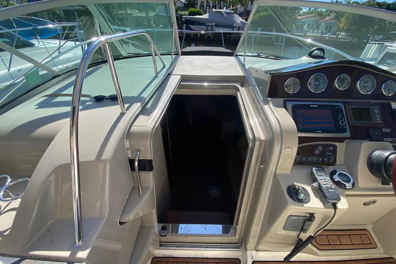 Slide: The Image of 2012 Sea Ray 330 Sundancer helm with navigation controls and cabin entrance. - 26